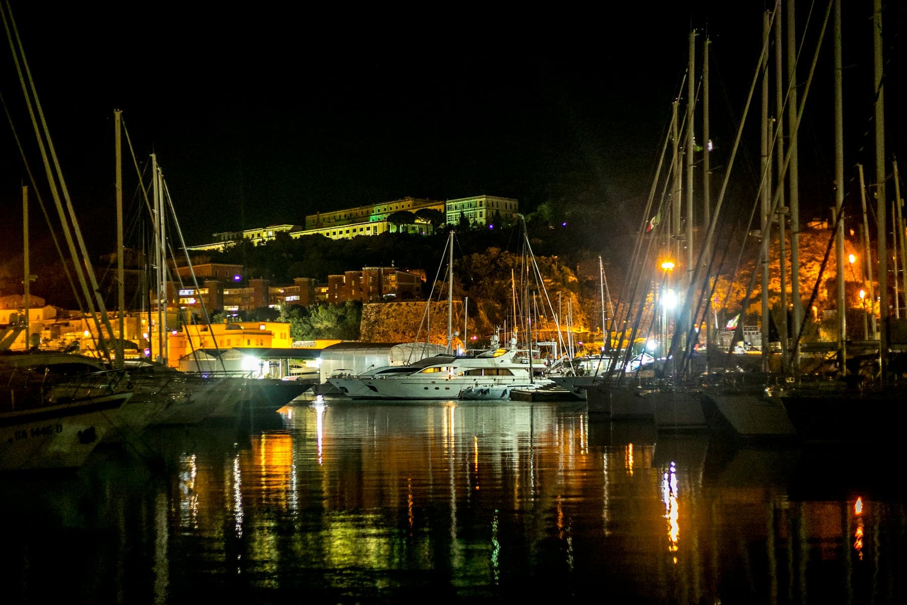 Yachts moored in a marina at night